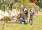 Scouts place flags on graves of veterans