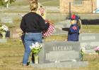 Scouts place flags on graves of veterans